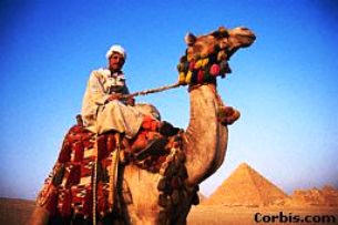 A picture of a man riding a camel.